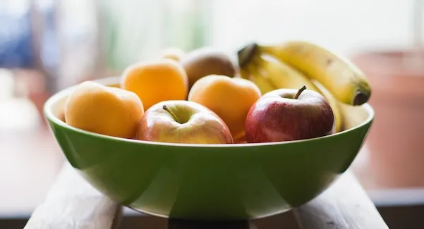 Яблоко, банан, абрикос на столе